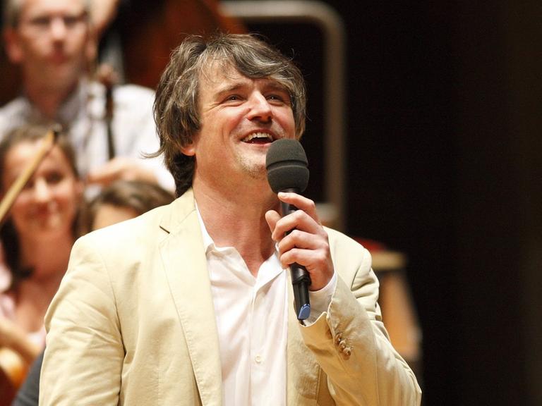 Der Dirigent Ingo Metzmacher im Halbporträt lachend beim casual concert in der Berliner Philharmonie.