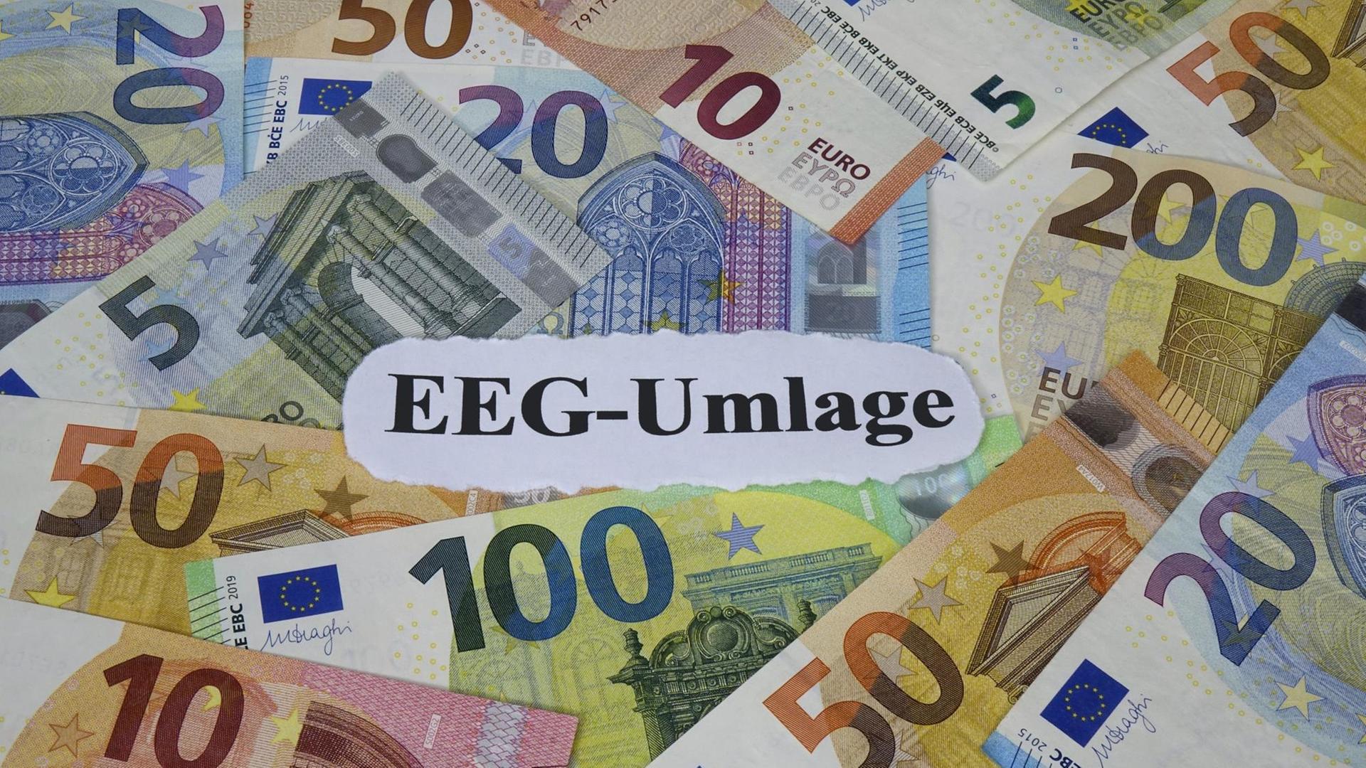 Auf Geldscheinen liegt ein Schriftzug, auf dem "EEG Umlage" zu lesen steht. Auf Geldscheinen liegt ein Schriftzug, auf dem "EEG Umlage" zu lesen steht.