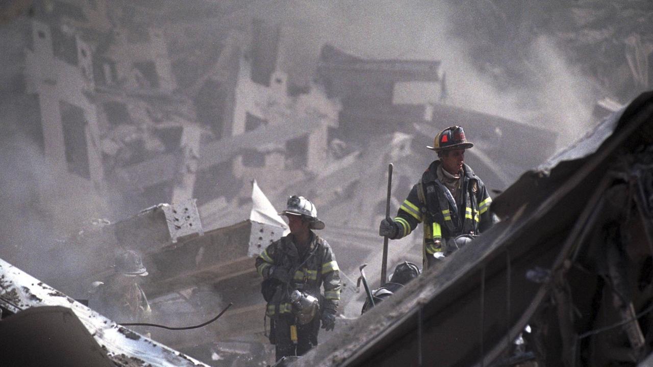 Feuerwehrmänner in Trümmern des zusammengestürzten World Trade Centers.