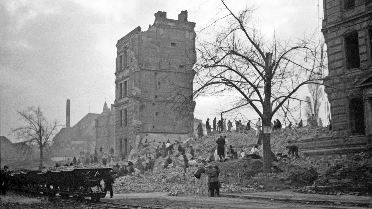 Schwarzweiß Fotografie von Ruinen und Trümmerfrauen.