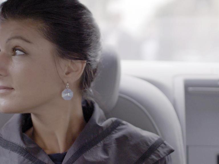 Die Politikerin Sahra Wagenknecht sitzt in einem Auto und schaut aus dem Fenster.