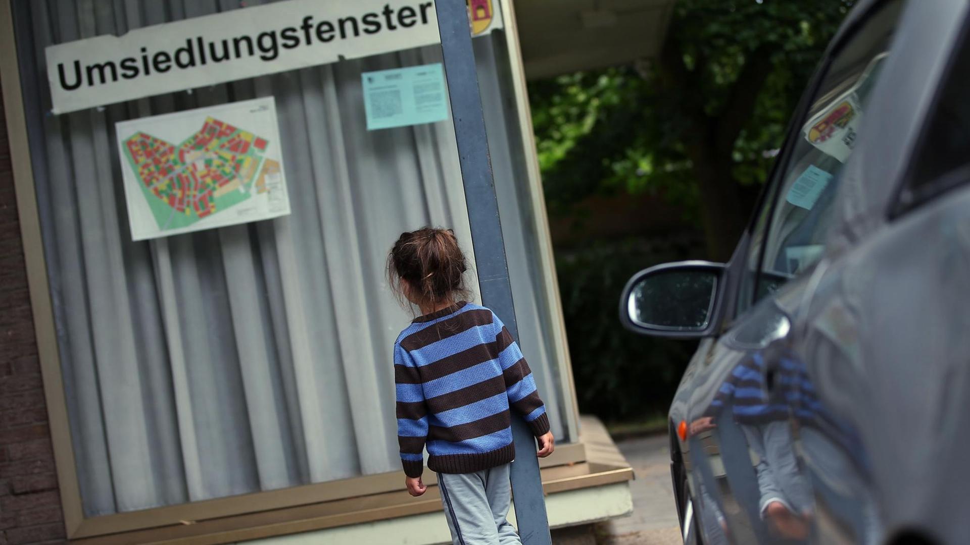 Das Kind einer Flüchtlingsfamilie in Kerpen-Manheim (Nordrhein-Westfalen) vor der Gemeindeverwaltung, die die Umsiedlung der Bewohner im Braunkohletagebau organisiert