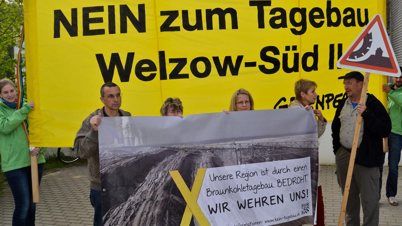 Blick auf Braunkohlegegner und Greenpeace-Aktivisten, die mit einem Transparent mit der Aufschrift "Kein Plan für die Zukunft - Nein zum Tagebau Welzow-Süd II" vor der Sitzung des Braunkohlenausschusses in Cottbus (Brandenburg) protestieren.