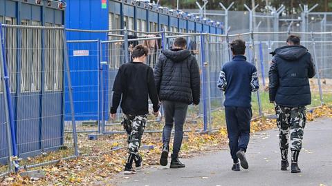 Flüchtlinge gehen über das Gelände der Zentralen Erstaufnahmeeinrichtung für Asylbewerber (ZABH) des Landes Brandenburg.