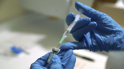 Eine Impfung mit dem Pfizer/Biontech-Impfstoff wird vorbereitet. Dazu wird der Stoff mit einer Spritze aufgenommen.