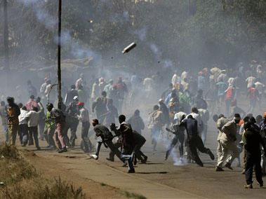 Demonstranten in einem Slum von Nairobi rennen weg, während die Sicherheitskräfte Tränengas versprühen.
