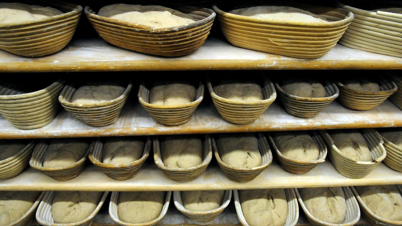 Brotrohlinge liegen in Holzkörben einer Bäckerei.