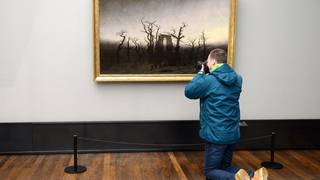 Ein Journalist fotografiert am 21.01.2016 in der Alten Nationalgalerie in Berlin das restaurierte Werk "Abtei im Eichwald" des Malers Caspar David Friedrich.