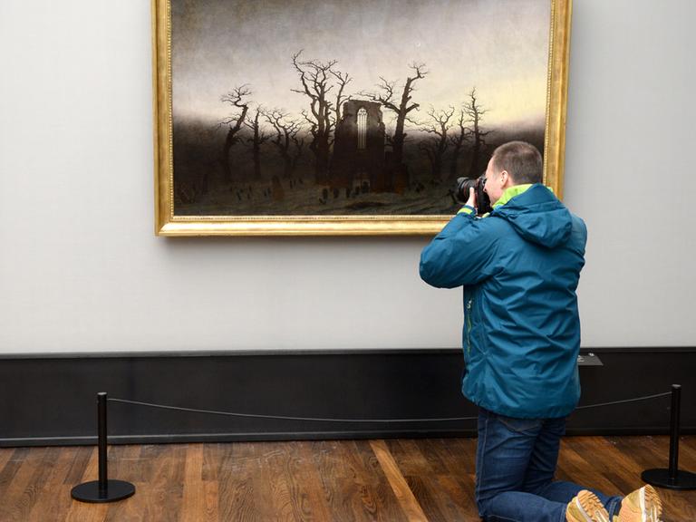 Ein Journalist fotografiert am 21.01.2016 in der Alten Nationalgalerie in Berlin das restaurierte Werk "Abtei im Eichwald" des Malers Caspar David Friedrich.
