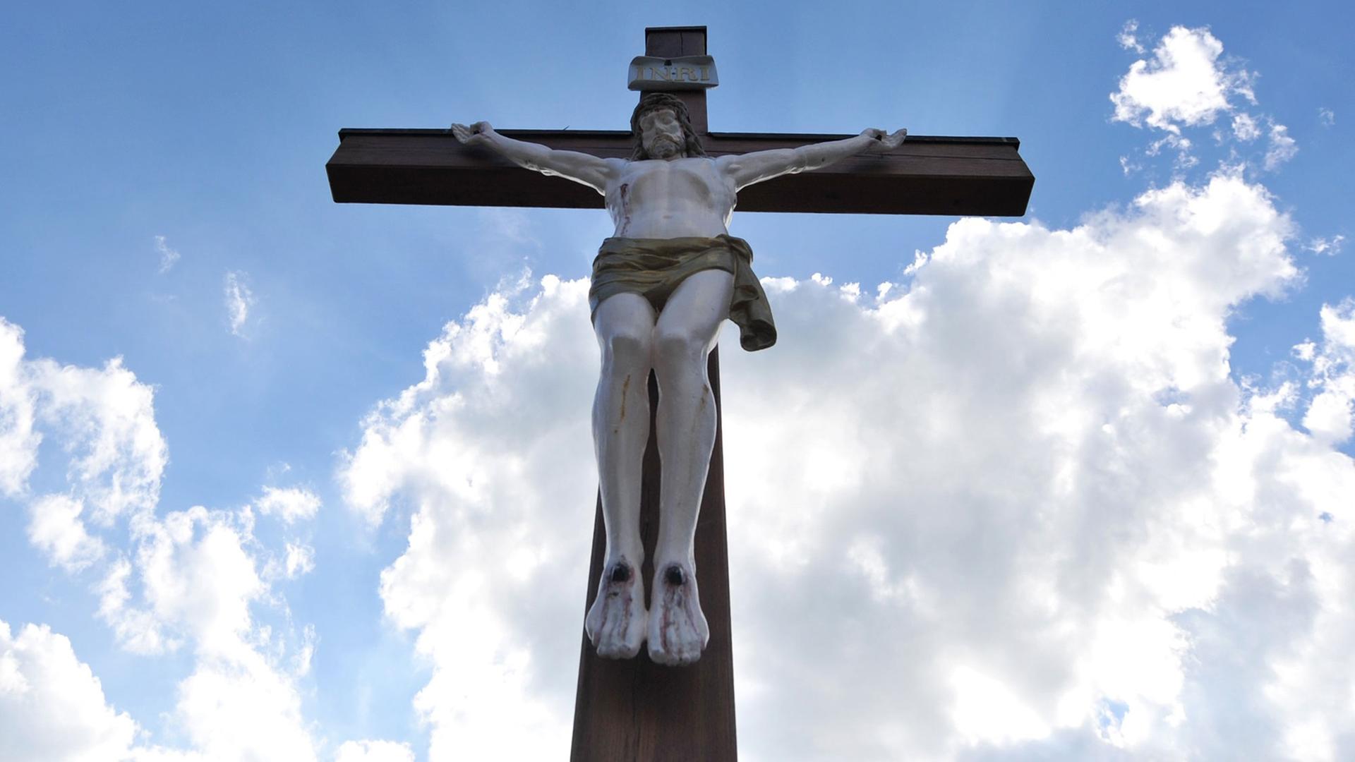 Ein Holzkreuz mit Jesusfigur steht auf dem Friedhof Hochmutting in Oberschleißheim (Bayern).