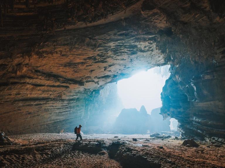 Ein Wanderer in einer Grotte.