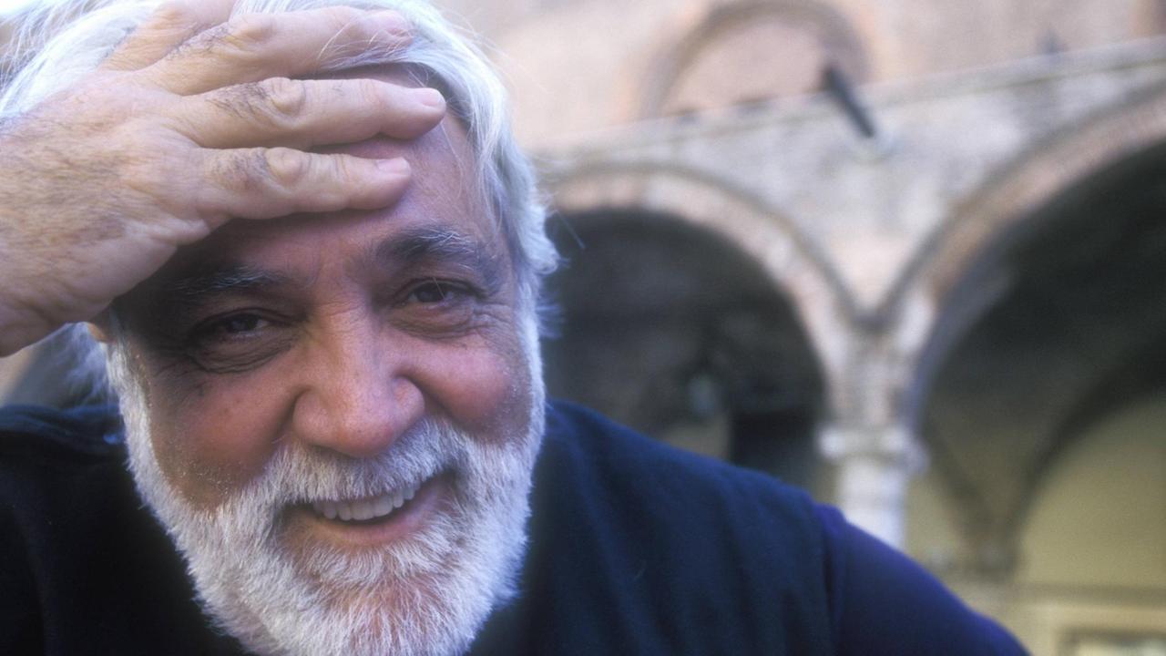 Der urugayisch-kubanische Schriftsteller Daniel Chavarria beim Festivaletteratura di Mantova 1998. Chavarría, mit weißmeliertem Bart, schaut in die Kamera und fasst sich mit der Hand an die Stirn.