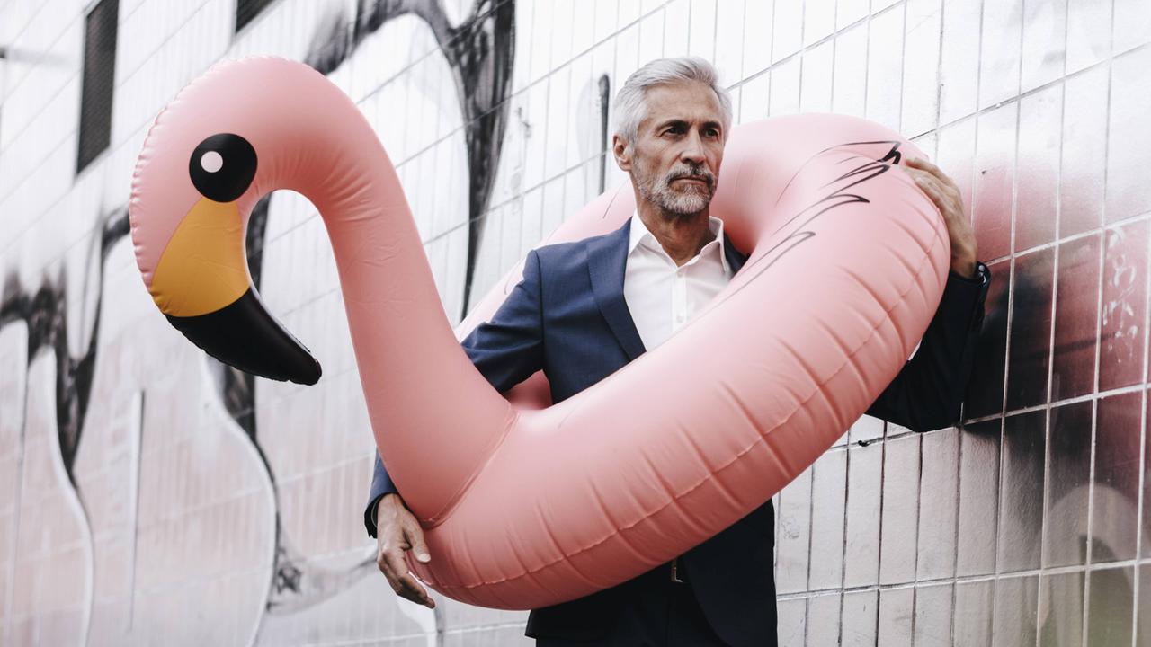 Ein Geschäftsmann mit aufblasbarem Flamingo
