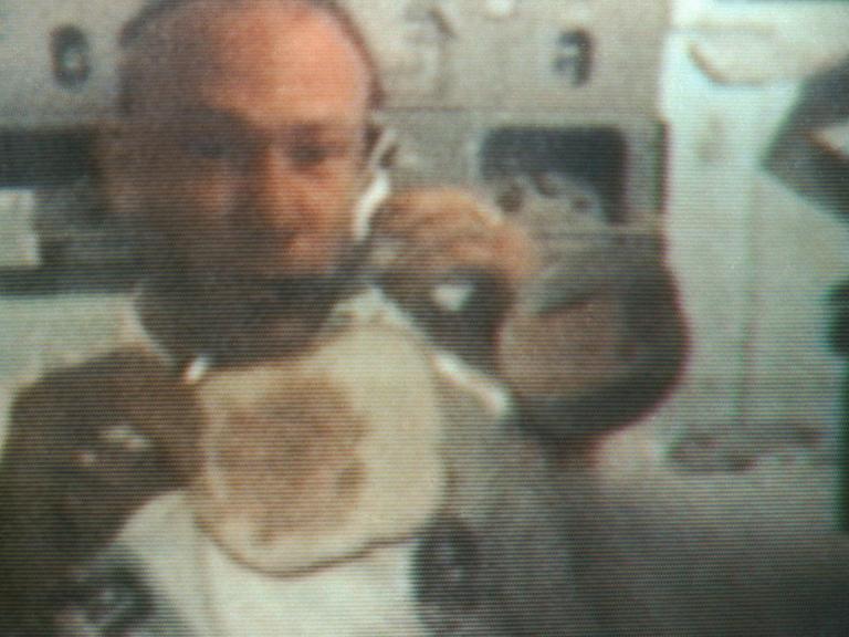 Der Apollo 11-Astronaut Edwin E. Aldrin Jr. zeigt Fernseh-Zuschauern in einer Übertragung aus der Raumkapsel wie man unter Schwerkraft ein Sandwich macht