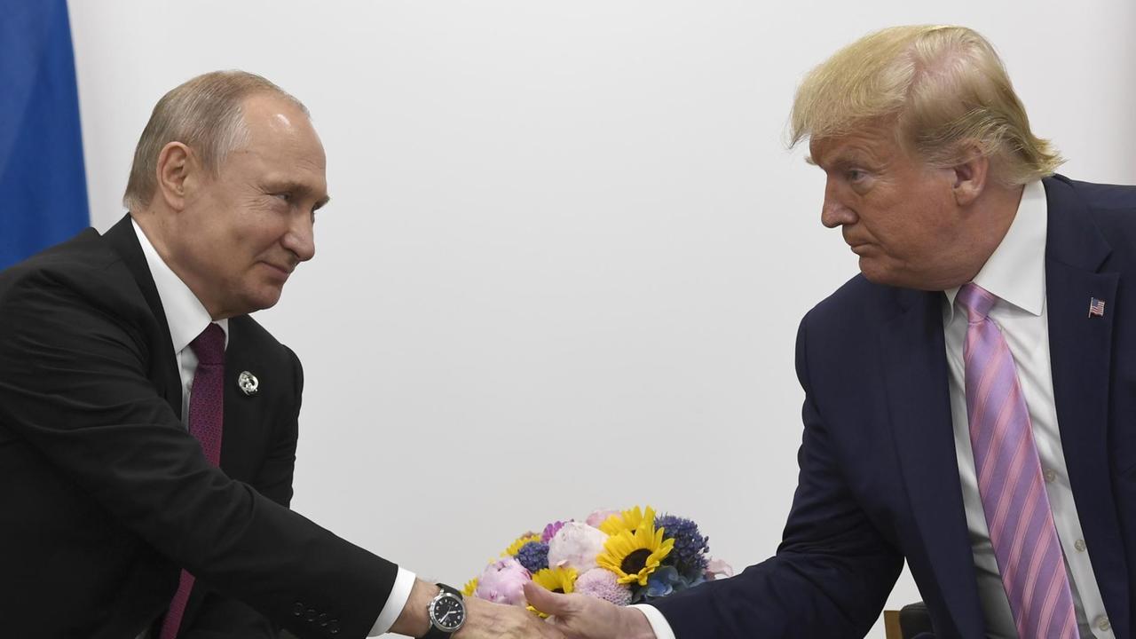 US-Präsident Donald Trump wird per Handschlag vom russischen Präsidenten Vladimir Putin begrüßt.