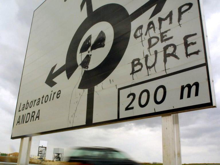 Ein Verkehrsschild, das mit einem Atomkraftzeichen und dem Hinweis auf "Camp De Bure" übermalt wurde