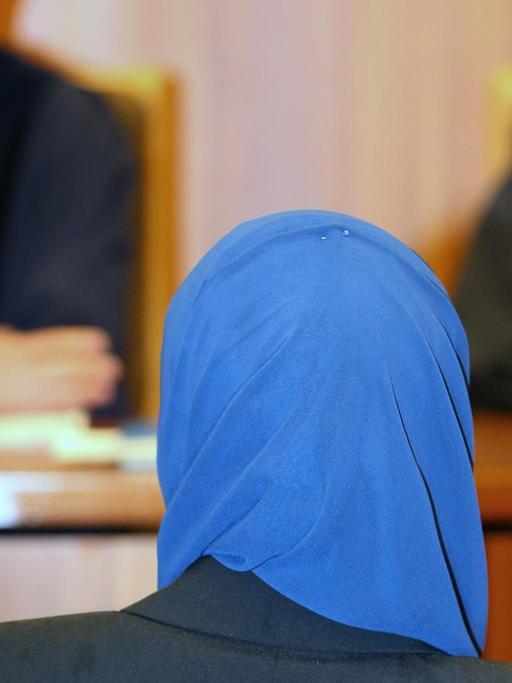 Aquila S. sitzt am 30.06.2016 im Verwaltungsgericht in Augsburg (Bayern) vor Richter Bernhard Röthinger (l). Die Jurastudentin klagt vor dem Gericht gegen Einschränkungen beim Rechtsreferendariat wegen des Tragens eines Kopftuches.