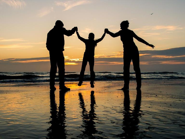 Eine Familie im Sonnenuntergang am Meer