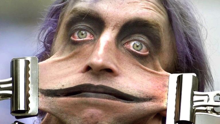 Ein Mitglied des Circus of Horrors zeigt seine Nummer, als die Edinburgh Fringe Parade am 4.8.2002 durch Edinburgh zieht.