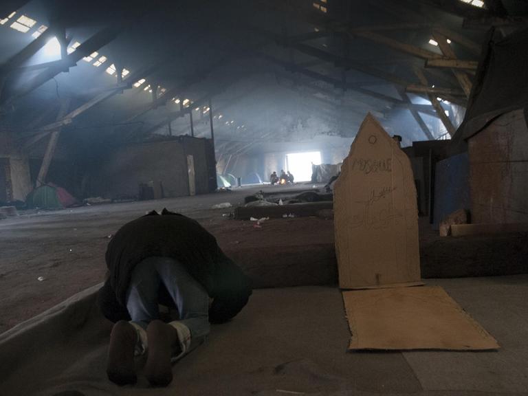 Junger Muslim betet in einer illegalen Flüchtlingsunterkunft in Belgrad