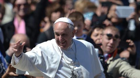 Der Papst nach der Ostermesse in einer jubelnden Menschenmenge. Er winkt und lacht.