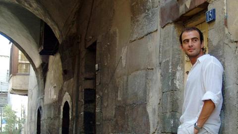 Der syrische Klarinettenspieler Kinan Azmeh steht unter einem Torbogen