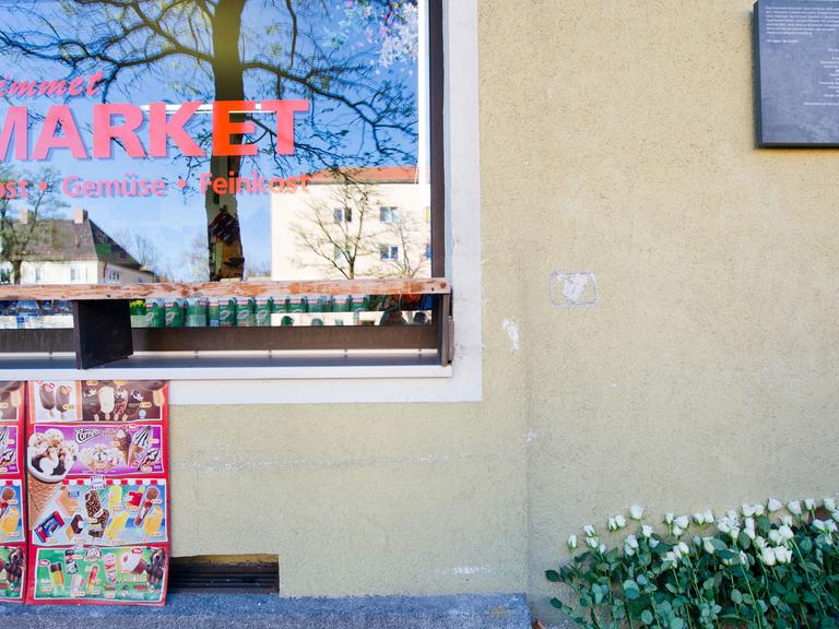 Weiße Rosen liegen am 08.11.2013 vor der Gedenktafel für Habil Kiliç, ein Todesopfer des NSU-Terrors, in München (Bayern). Das Mahnmal soll hier an die insgesamt zehn Menschen erinnern, die zwischen 2000 und 2007 mutmaßlich durch die Terrorzelle ermordet wurden. Der Stein führt die Namen der zehn Getöteten, die Orte und das jeweilige Datum der Verbrechen auf.