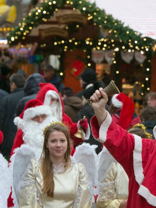 Zu sehen sind Weihnachtsmänner und Engel auf dem Weihnachtsmarkt an der Gedächtniskirche in Berlin