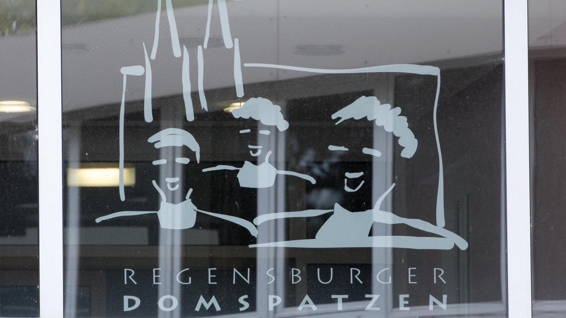 Das Logo der Dom-Spatzen: Singende Köpfe vor Kirch-Türmen