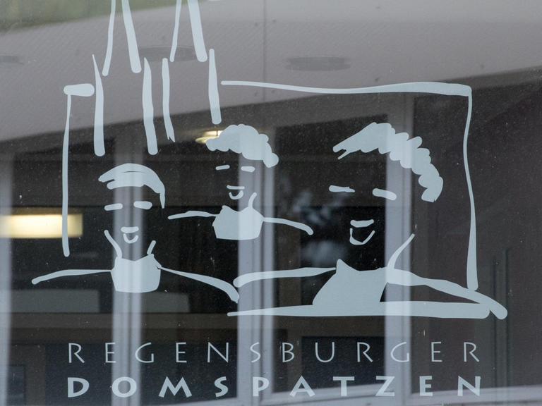 Das Logo der Dom-Spatzen: Singende Köpfe vor Kirch-Türmen