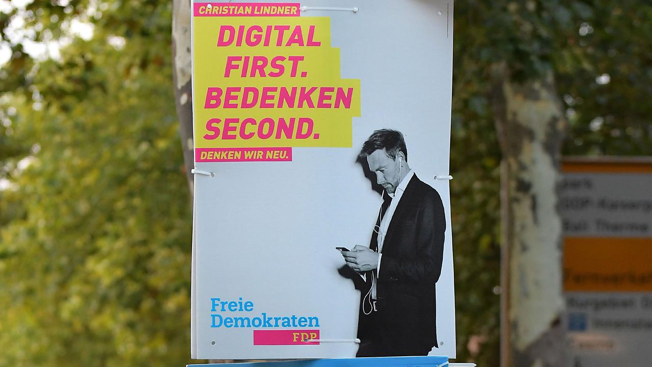 Ein Wahlplakat der Partei FDP mit Spitzenkandidat Christian Lindner, der auf sein Smartphone schaut und dem Slogan "Digital first. Bedenken second."