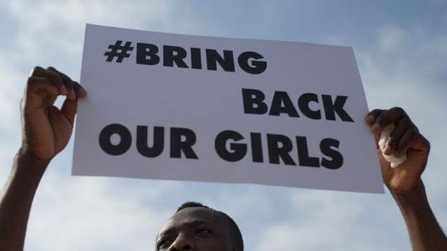 Ein Mann hält ein Blatt Papier mit der Aufschrift "Bring Back our girls" hoch