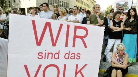 Bürger demonstrieren mit einem Transparent "Wir sind das Volk" während einer Kundgebung am  9. August 2004 in der Innenstadt von Jena