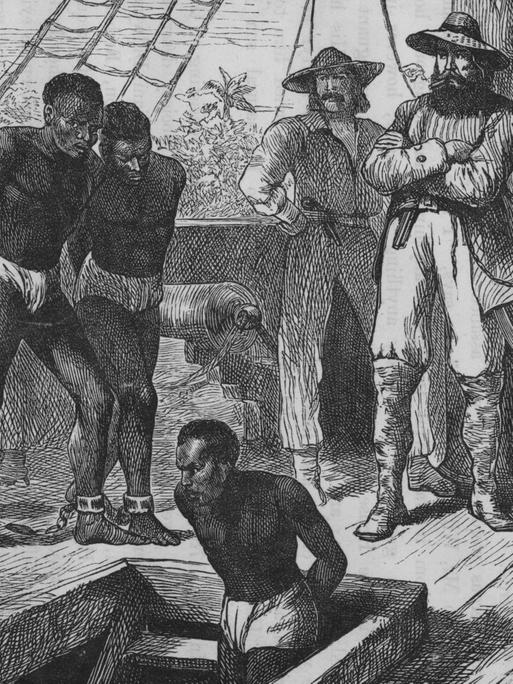 Eine historische Illustration um 1835 zeigt Sklaven an Bord eines Sklavenschiffes, die gefesselt werden, bevor sie in den Laderaum gebracht werden.