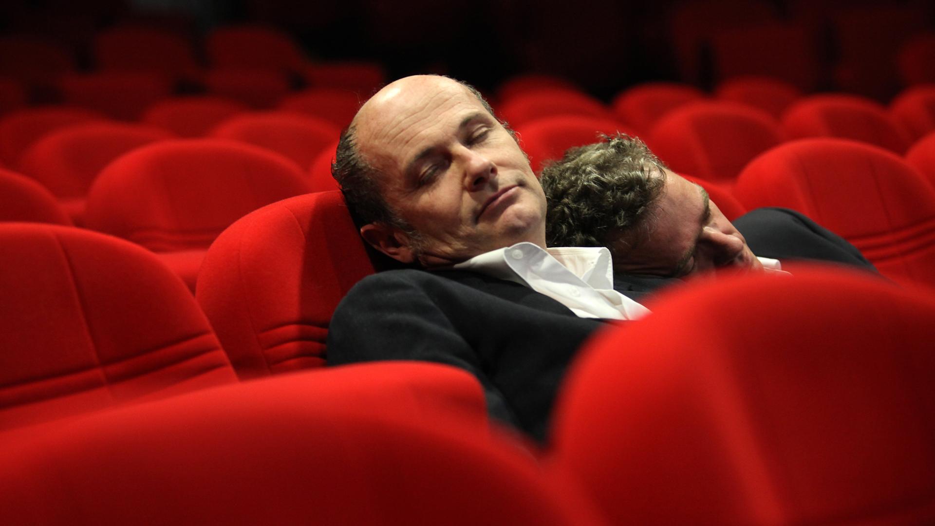 Thomas Pigor und Benedikt Eichhorn sitzen in einem Theatersaal und schlafen.