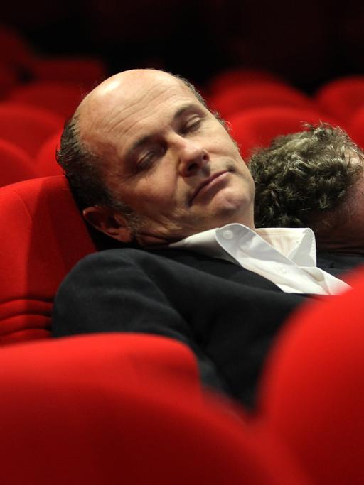 Pigor & Eichhorn liegen aneinandergelehnt und schlafend in roten Theatersesseln.