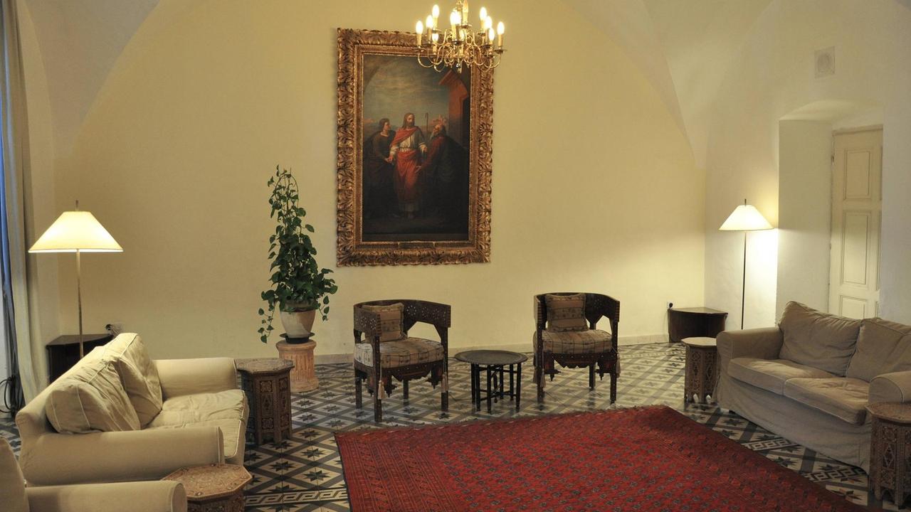 Foyer im Österreichischen Hospiz zur Heiligen Familie in Jerusalem. Eine Sitzecke mit alten Stühlen und Sofas. 