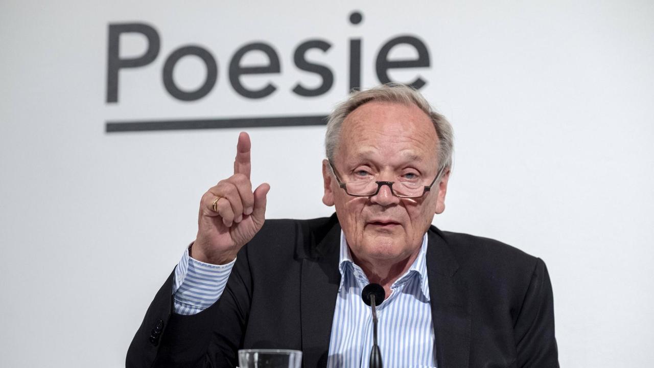 Kritiker Joachim Sartorius auf der Bühne im Haus der Poesie, in Berlin. Im Hintergrund ist der Schriftzug "Poesie" zu sehen.