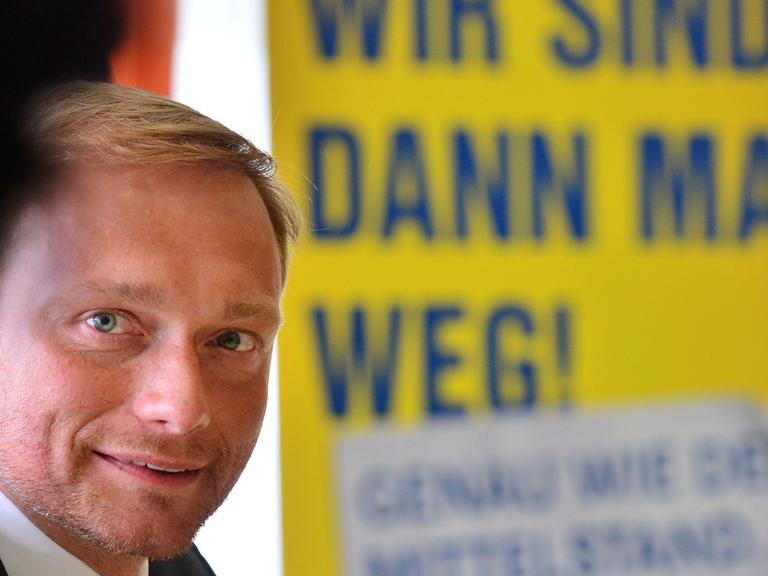 Der FDP-Bundesvorsitzende, Christian Lindner, sitzt am 06.08.2014 in Erfurt (Thüringen) bei einer Wahlkampfveranstaltung vor einem Wahlplakat der Thüringer FDP auf dem steht: "Wir sind dann mal weg. Genauso wie der Mittelstand"