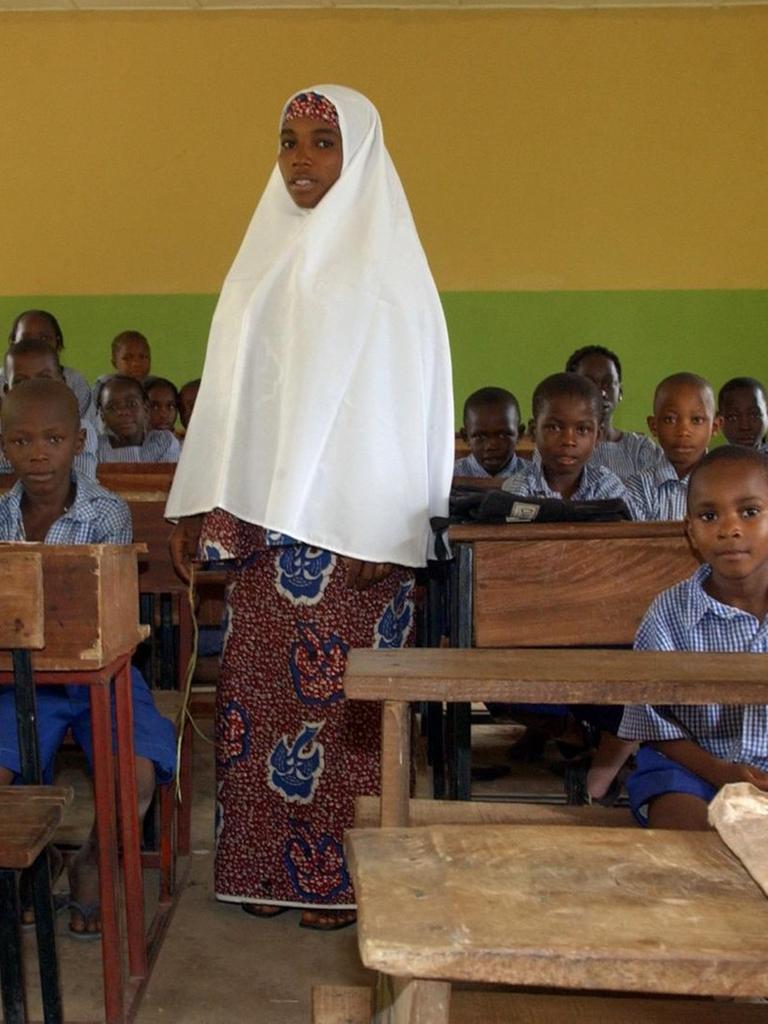 Eine junge muslimische Lehrerin steht am Dienstag (20.09.2005) in einer Schule in den Bergen nördlich von Abuja, der Hauptstadt des westafrikanischen Staates Nigeria, im Klassenzimmer zwischen ihren Schülern.