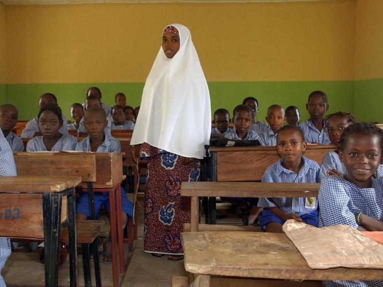 Eine junge muslimische Lehrerin steht am Dienstag (20.09.2005) in einer Schule in den Bergen nördlich von Abuja, der Hauptstadt des westafrikanischen Staates Nigeria, im Klassenzimmer zwischen ihren Schülern.