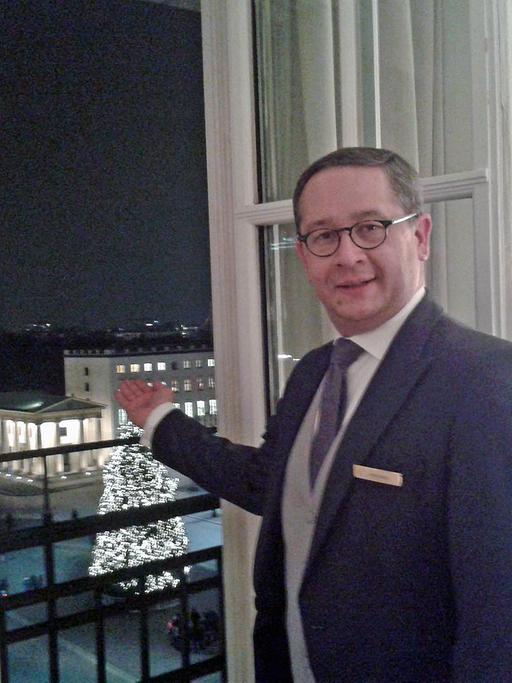Der Butler Ricardo des Hotels Adlon präsentiert den Blick auf das Brandenburger Tor aus der Präsidentensuite.
