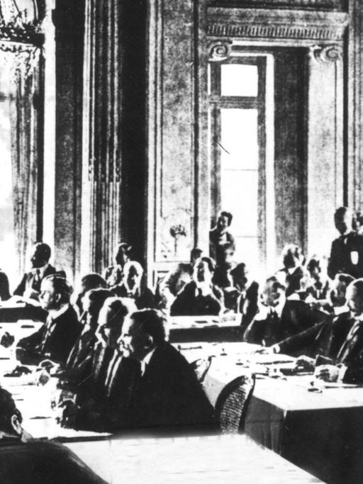 Die Sitzung vom 7. Mai 1919, in der der Vertragstext der deutschen Delegation zugestellt wurde. Der Versailler Vertrag war der wichtigste der Pariser Vorortverträge, die 1919/20 den 1. Weltkrieg beendeten. Der Versailler Vertrag wurde am 28.6.1919 im Versailler Schloß zwischen Deutschland und 27 alliierten und assoziierten Mächten unterzeichnet und trat am 20.1.1920 in Kraft. Ohne deutsche Beteiligung wurde ab dem 18.1.1919 in Paris der Text des Friedensvertrages zwischen Wilson, Lloyd George, Clemenceau und Orlando (Die "Großen Vier") ausgearbeitet. Am 7.5.1919 wurde der Text der Deutschen Delegation zugestellt