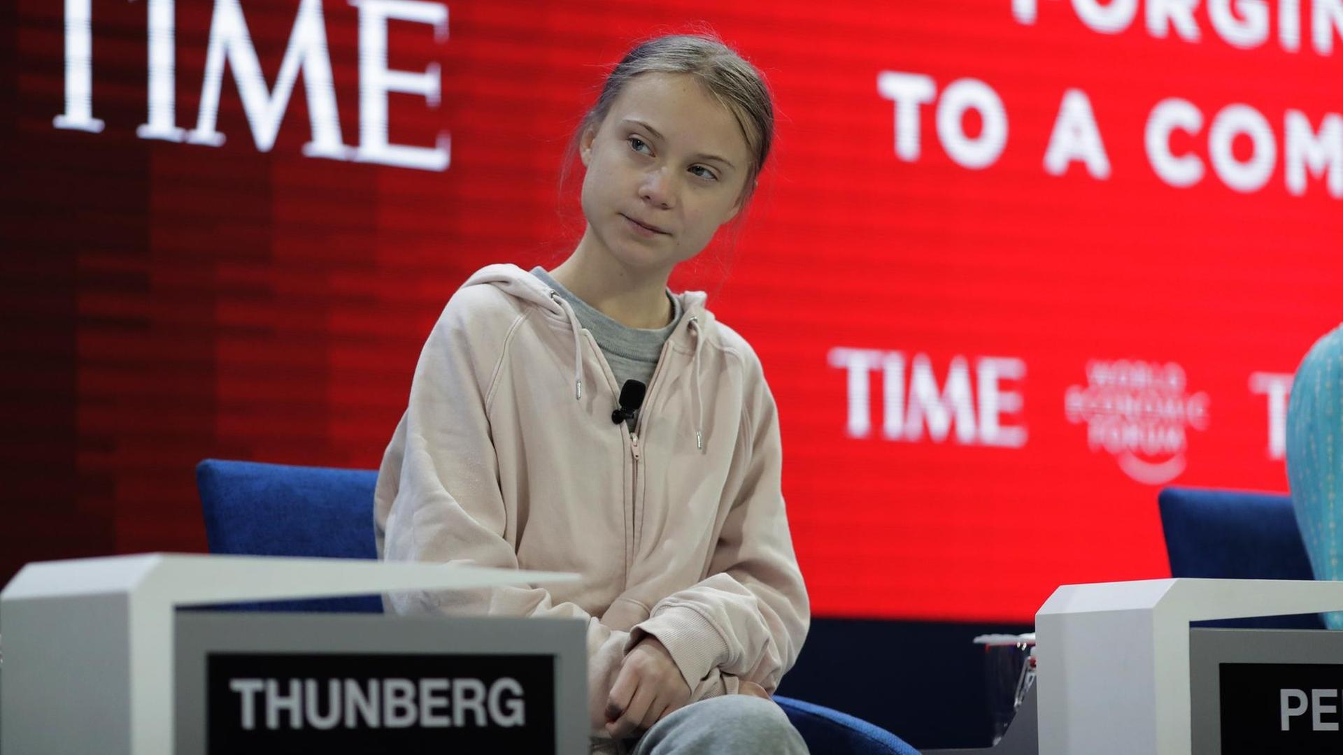 Die Klima-Aktivistin Greta Thunberg sitzt beim Wirtschafts-Treffen in Davos in der Schweiz auf einer Bühne.