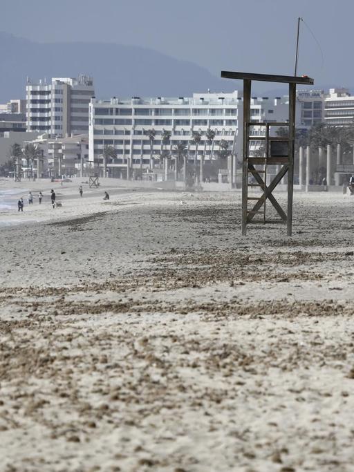 Ein Mann geht am Strand von Arenal auf Mallorca über den Sand. Deutsche Reiseveranstalter hoffen, dass sie Urlauber ab den Osterferien wieder nach Mallorca bringen können.