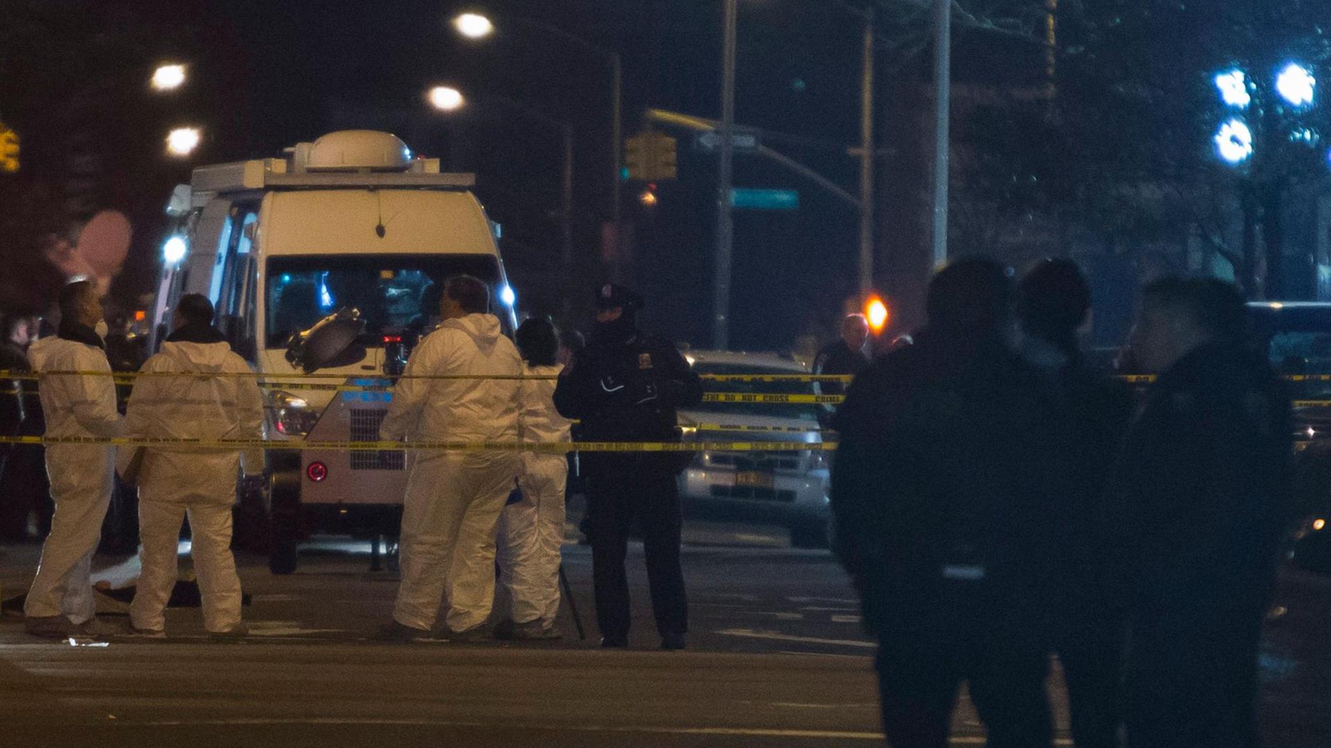 Beamte untersuchen in Brooklyn den Tatort, an dem zwei Polizisten in ihrem Streifenwagen erschossen wurden.