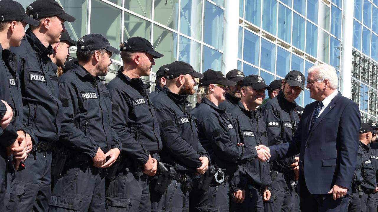 Bundespräsident Steinmeier schüttelt Polizisten die Hand, um sich für deren Einsatz beim G20-Gipfel zu bedanken.