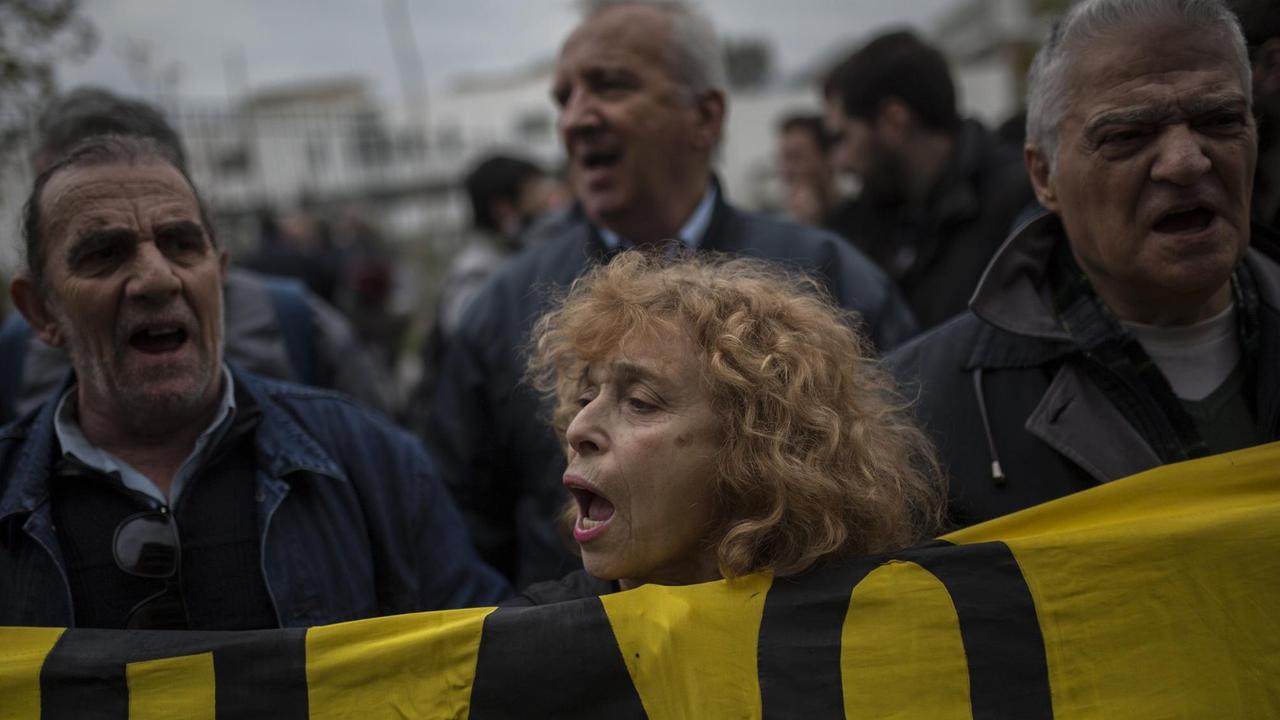Teilnehmer und Teilnehmerinnen einer Demonstration skandieren am 10.01.2018 vor einem Gericht in Athen (Griechenland) Parolen gegen Zwangsversteigerungen.
