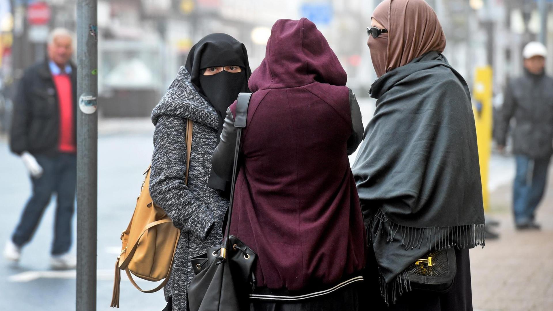 Drei vollverschleierte Frauen stehen am 20.10.2016 zum Prozessauftakt gegen Safia S. vor dem Oberlandesgericht in Celle (Niedersachsen), in dem sich die inzwischen 16-jährige IS-Sympathisantin Safia S. nach einer Messerattacke auf einen Polizisten wegen versuchten Mordes und Unterstützung der Terrormiliz IS verantworten muss.