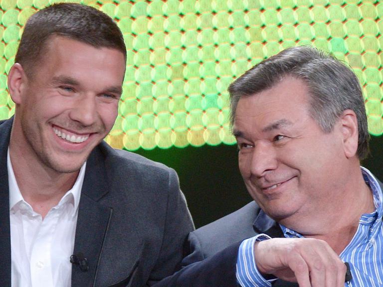 Der Fußballer Lukas Podolski (l) und der Journalist Waldemar Hartmann, hier beim RTL-Jahresrückblick "Menschen, Bilder, Emotionen" 2013